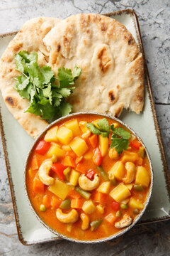 Vegetable korma is a rich and creamy Indian curry loaded with warm spices and tender veggies closeup on the bowl on the table. Vertical top view from above