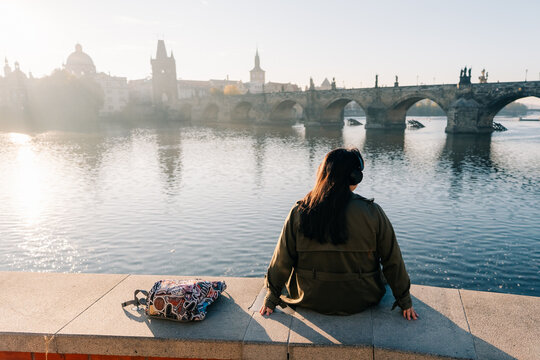 tourist enjoys view of Charles Bridge over Vltava River in Prague