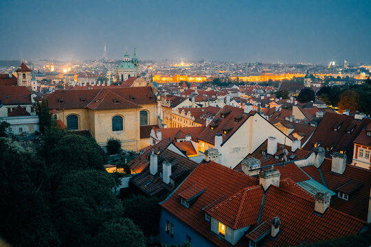 City skyline view at night with glowing lights and rooftops in Prague