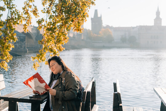 Korean woman exploring Prague by water while examining map