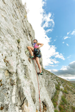 Women climbing a rock face outdoors during a daytime climb