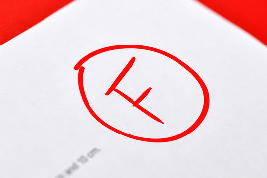 Close up of F grade marked in red on a school exam paper symbolizing academic failure