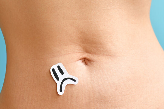 Sad  face on woman abdomen symbolizing menstrual pain, endometriosis, fertility issues and reproductive health problems