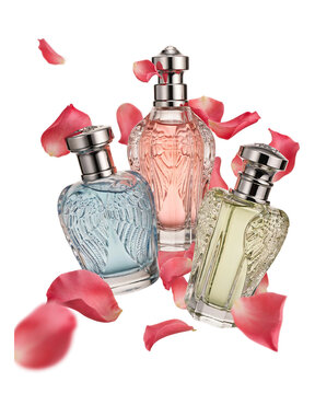 Three decorative perfume bottles arranged with floating rose petals essential oil still life white background beauty product luxury brand floral water