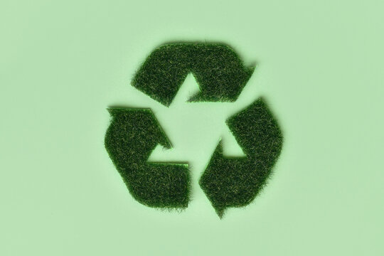 Recycling arrow symbol made from grass on green background