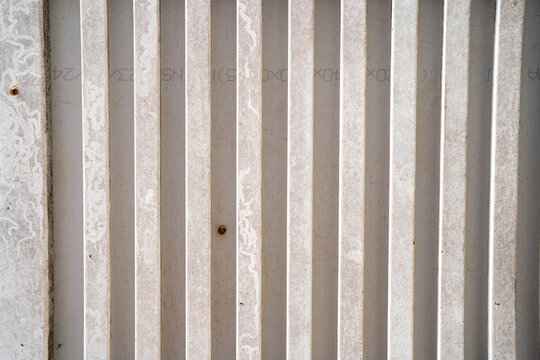 Textured white wall with vertical lines and subtle weathering.