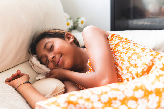Innocent girl sleeping on bed at home