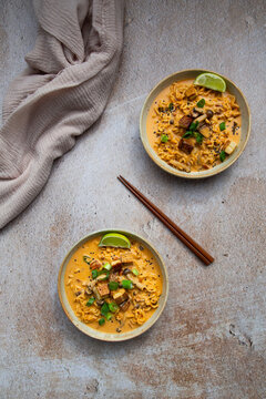 Vegan peanut ramen with crispy tofu sits on a textured table