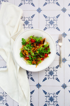 Vegan lemon chicken mixed salad with tomato and carrot in a bowl
