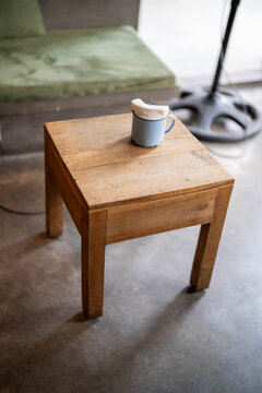 A simple wooden table with a blue mug atop, showcasing rustic charm.