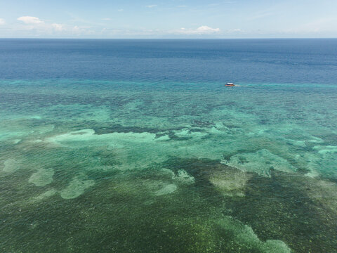 Aerial view of coral reef and boat in Anda Bohol Philippines
