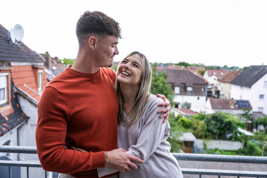 Happy man and woman hug on their home terrace