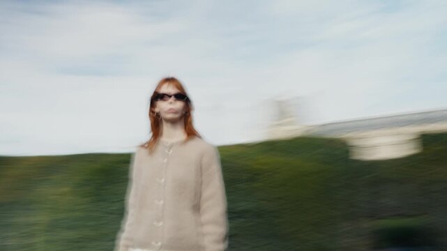 Disoriented redhead woman spinning in a park
