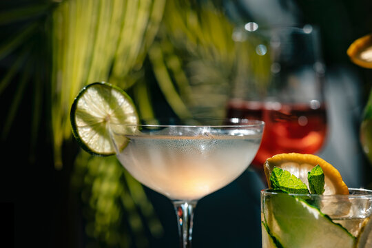 Iced cold cocktail daiquiri in glass &mdash; ultimate cooling summer drink. Carefree lifestyle and weekend relaxation. Alcoholic mix with lime juice and strong rum covered in fresh water drops under sun.