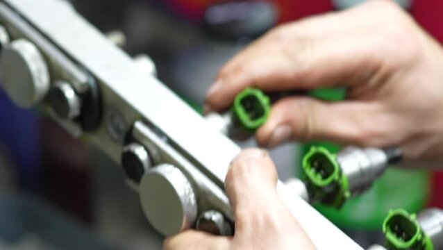 Technician installing green connectors into engine block components during repair