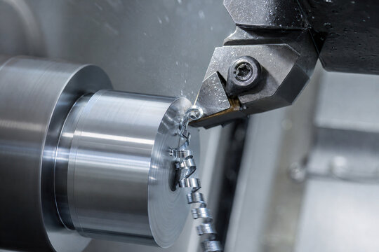 Close up of CNC lathe cutting metal cylinder with precision tool and coolant spray. Industrial manufacturing, engineering, machining, and automated production concept.