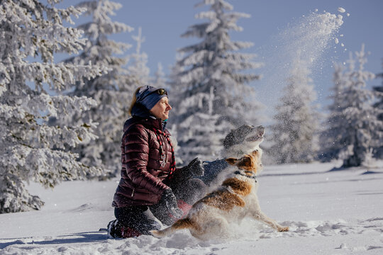 Woman with dogs playing outdoors in winter in great snow. 
