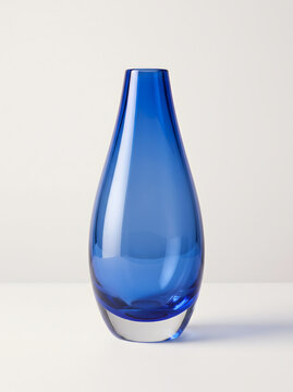 Stunning blue glass vase with a sleek, minimalist design, captured in a clean studio shot. This elegant and modern decorative object is ideal for enhancing contemporary home interiors, providing a...
