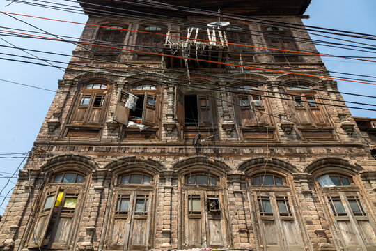 Facade of an old decaying wooden house tangled with electric wires, Jammu and Kashmir, Srinagar, India