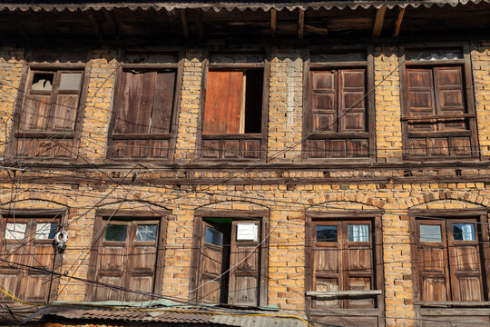 Facade of an old yellow brick house with wooden shutters, Jammu and Kashmir, Srinagar, India