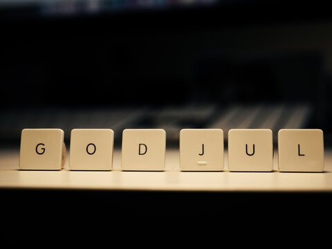 God Jul on keys with a dark office background, Scandinavian Merry Christmas