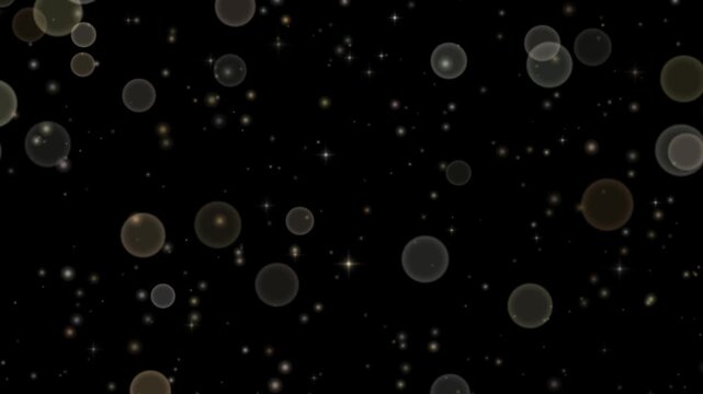 Champagne gold dust motes floating slowly across a black background with large soft out of focus particles passing in front of smaller sharp twinkling sparkles