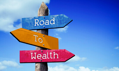 Road to wealth - colorful wooden signpost with three arrows, sky with clouds © PX Media