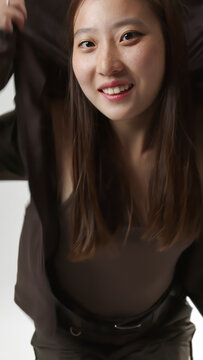 Cheerful Young Asian Woman Wearing Hooded Sweatshirt Portrait