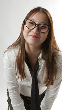 Smiling Young Asian Woman Wearing Black Eyeglasses in White Shirt and Tie