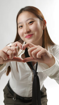 Young Asian Woman Making Heart Shape Gesture with Hands