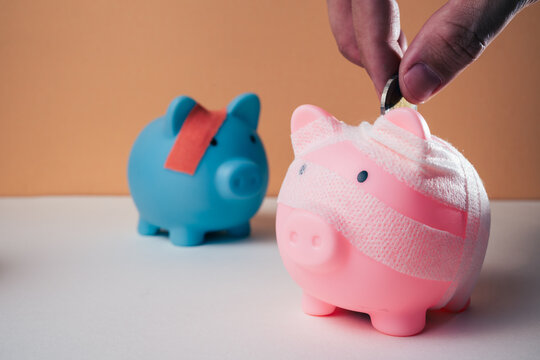 Piggy bank wrapped in a bandage on a plain background with copy space, representing financial recovery, debt relief, deposit protection, bankruptcy, business rehabilitation and a fresh start.