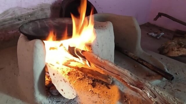Traditional Indian Wood Fired Chulha With Flame Cooking Roti in Rural Kitchen