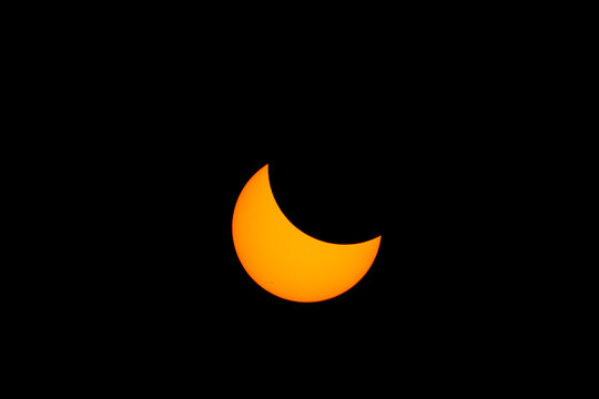 Partial solar eclipse with moon covering sun