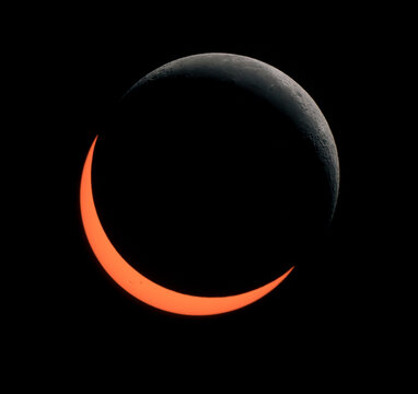 Partial solar eclipse with visible crescent moon and sun