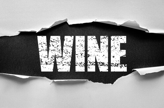 Word WINE displayed in bold distressed typography on a torn paper background. Concept of beverage, celebration, lifestyle, alcohol, elegance, and modern design message presentation