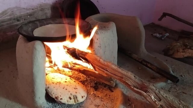 Traditional Indian Wood Fired Chulha With Flame Cooking Roti in Rural Kitchen