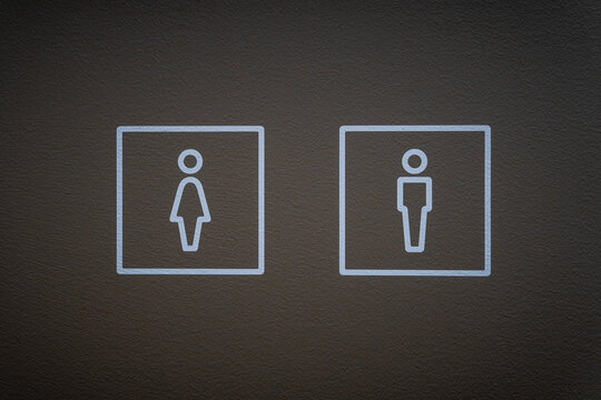 Men and Women Restroom Symbols on a Dark Textured Wall