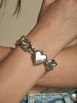 Close Up of Silver Chain Bracelet with Heart Shaped Pendant on Woman Wrist