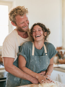 Happy Cheerful Couple Hugging and Laughing Together in Creative Workshop