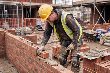 Obraz premium Bricklayer constructing a wall on building site
