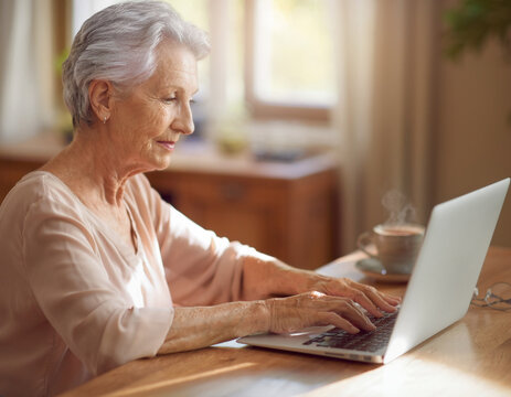Elderly person working on laptop at home office