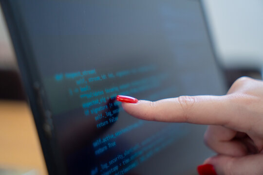 Programmer or IT pointing to code cybersecurity on laptop at home office for concept verifying code algorithm. Employees woman write code, typing on computer for software development. Remote work.
