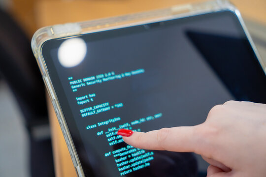 Programmer or IT pointing to code cybersecurity on laptop at home office for concept verifying code algorithm. Employees woman write code, typing on computer for software development. Remote work.