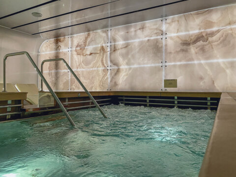 Indoor swimmingpool with hot tub whirlpool inside thermal suite in spa or wellness area onboard luxury modern cruiseship or cruise ship liner for beauty and balance