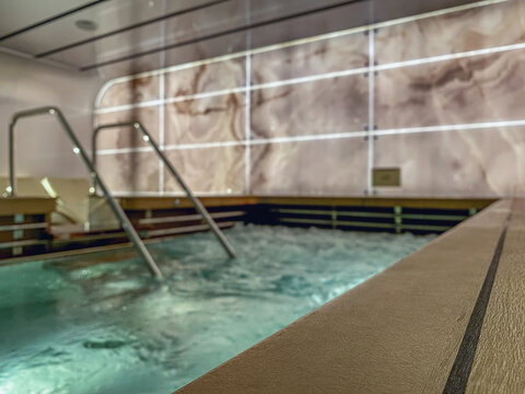 Indoor swimmingpool with hot tub whirlpool inside thermal suite in spa or wellness area onboard luxury modern cruiseship or cruise ship liner for beauty and balance