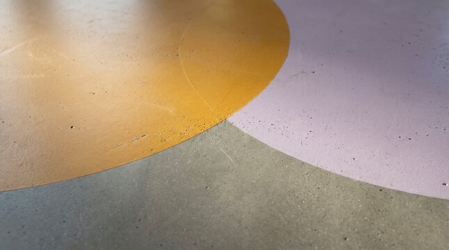 Painted concrete floor detail with overlapping mustard and lilac circles, rough texture background