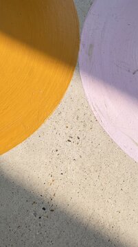 Abstract polished concrete floor with mustard and lilac circle, soft shadow and speckled texture
