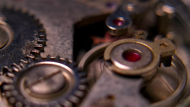 Macro shot of brass gears and hairspring balance wheel spinning inside mechanical watch movement