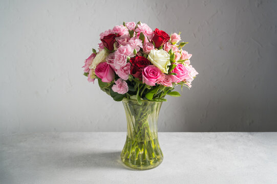 Mixed rose and carnation bouquet in a glass vase
