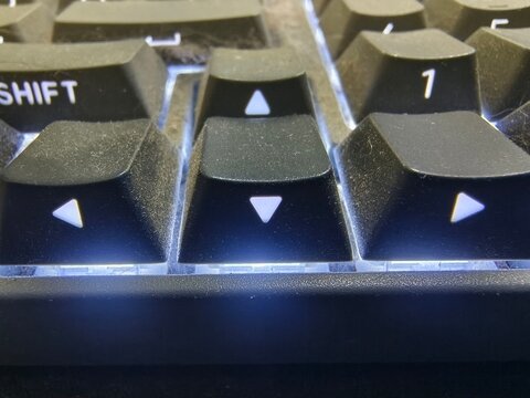 Close-Up View of Dirty Computer Keyboard Arrow Keys with Backlight Illumination